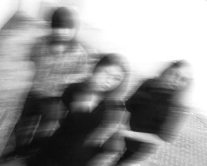 Bandfoto crush tones mit Bewegungsunschärfe
Drei Musiker sind in einer Schwarzweißaufnahme zu sehen. Durch starke Bewegungsunschärfe wirken Gesichter und Körper verschwommen und scheinen sich aufzulösen. Die Musiker stehen bzw. sitzen dicht beieinander in einem Innenraum. Die künstlerische Aufnahme erzeugt einen dynamischen und träumerischen Eindruck.