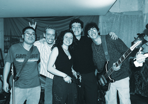 Bandfoto Bobby Pin: Bandfoto nach einem Auftritt
Fünf Musiker stehen eng beieinander auf einer Bühne und haben die Arme umeinandergelegt. Einer hält einen Bass, andere tragen Instrumentengurte. Die Aufnahme zeigt die Band in einer entspannten Stimmung nach einem Konzert.